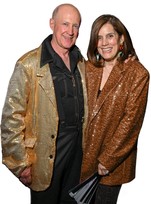 Craig and Kristin Shannon_cropped A photo of Craig and Shannon in their sparkly disco attire. Craig has his arm around Shannon and both have large smiles. Craig's jacket is gold sparkles and Shannon's jacket is copper sparkles.